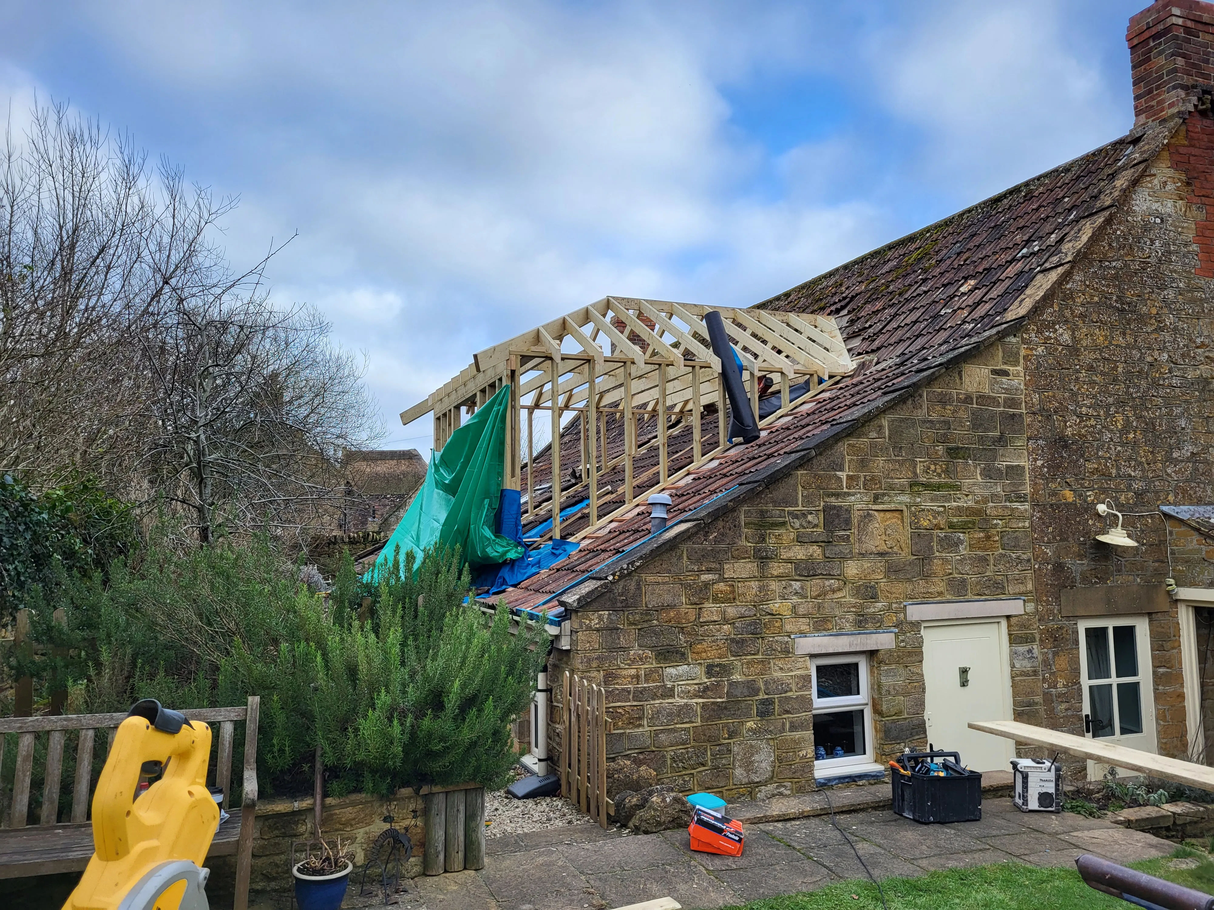 Loft conversion roof structure being built on Somerset stone cottage